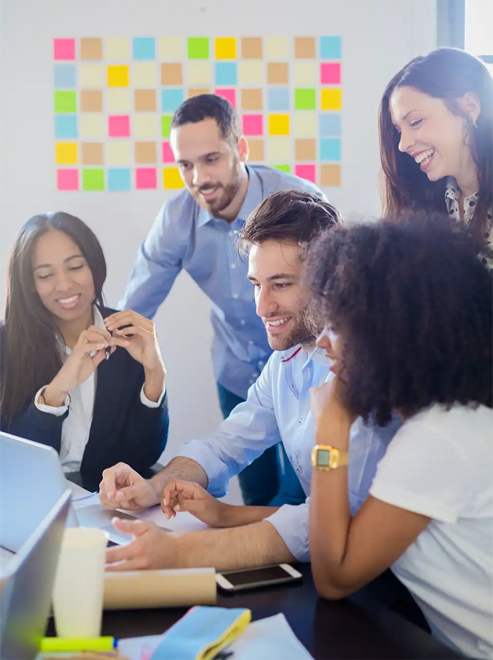 Group of employees having fun while working with pin paper in the background