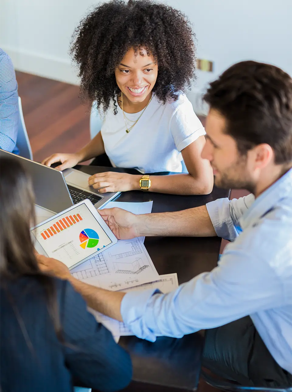 Two employees analyzing some charts on paper and talking with each other