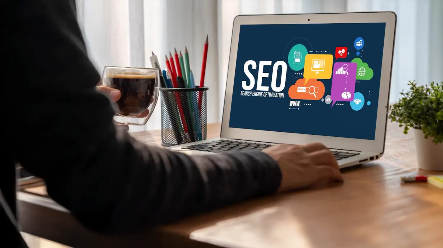 Man working on laptop displaying SEO icons